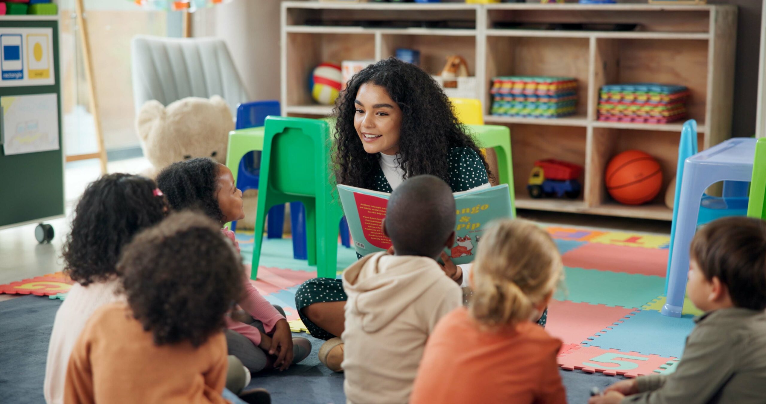 Reading, education and teacher with children in classroom for learning, books and students. Growth, kindergarten and academy with woman and kids at school for youth, story time and child development.